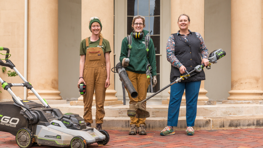 Tudor Place team poses with electric lawn care equipment in front of main building