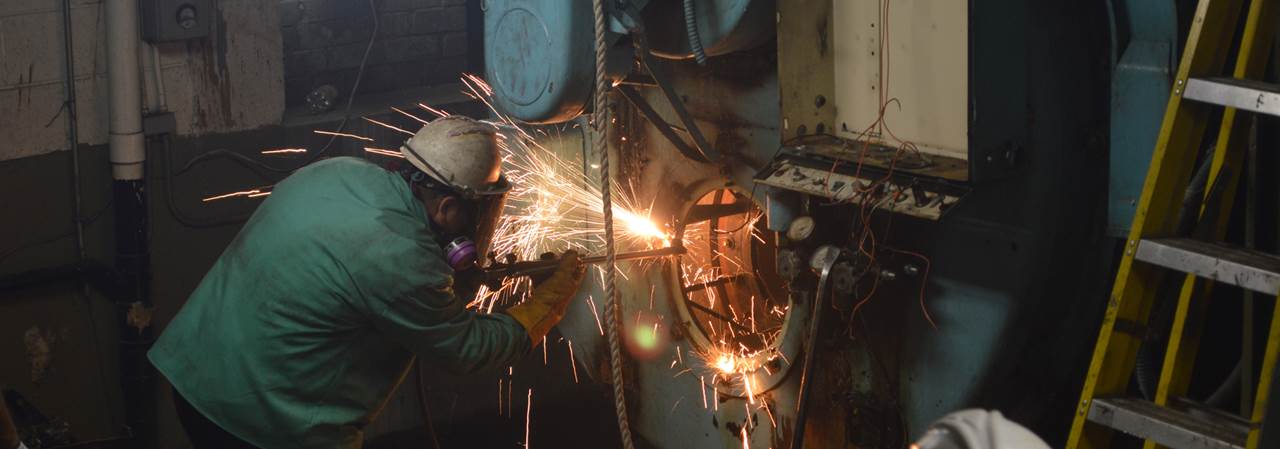 A worker welding a machine