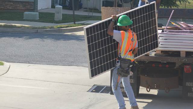 Photo of person working with solar panel