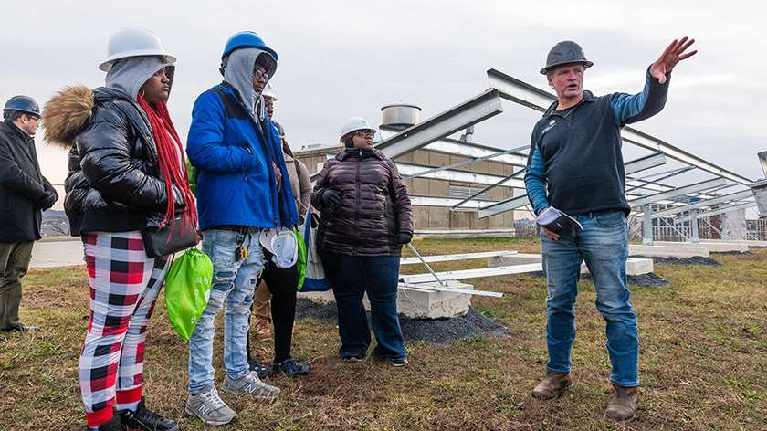 Contractor giving a tour of community solar site to high school students..
