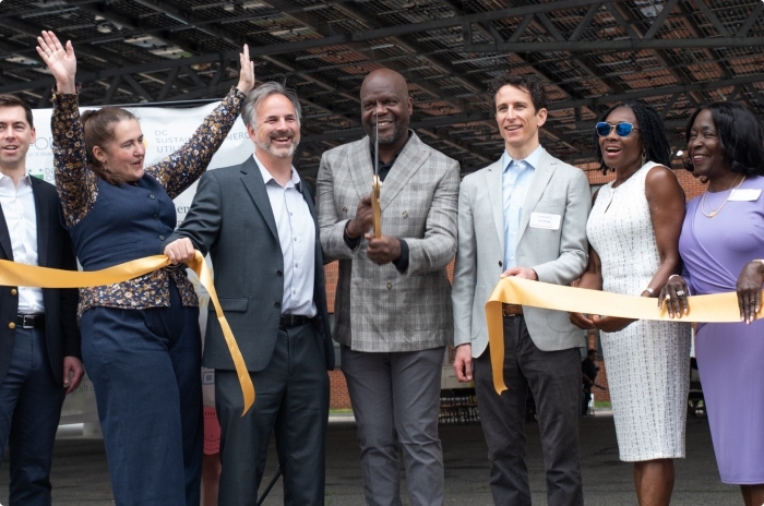 A group of DC community, private industry, and government leaders cutting the ribbon for a solar canopy at Sargent Memorial Presbyterian Church.