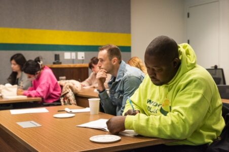 Row of students listening and taking notes in a classroom and office setting.