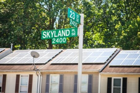 Skyland Place and 23rd Street signs with several DC row homes in the background with solar panels on the roofs.