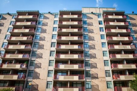 A large multifamily building facade in DC with repeating balconies.