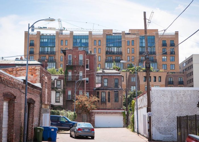View of the back of multiple multifamily buildings from an alleyway in DC.