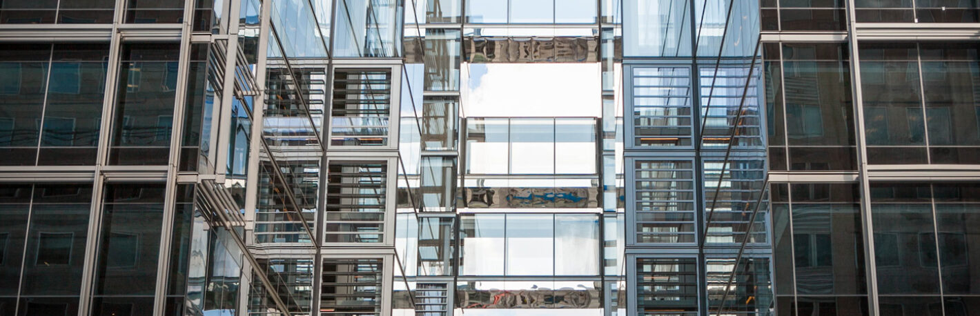 Detail of multiple glass walkways in an all-glass high rise commercial building.