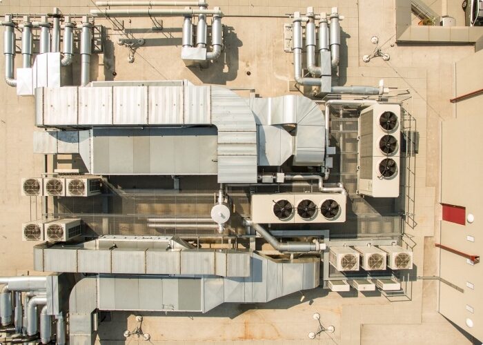 Aerial view of a commercial maintenance roof with a complex system of HVAC equipment.