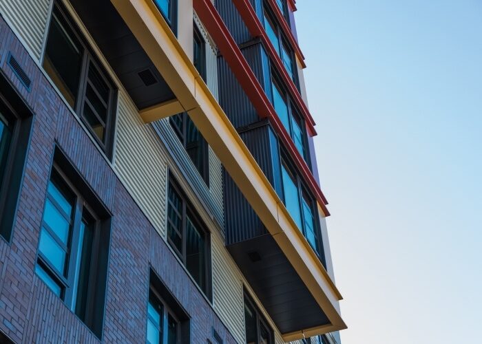 Colorful facade of a multifamily building from the ground-level perspective.