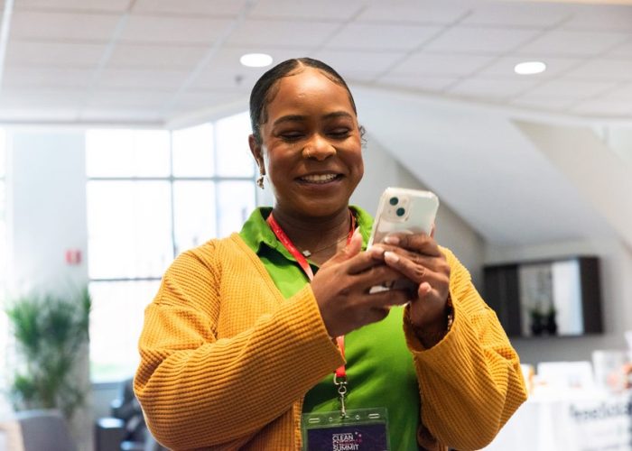 Karelene smiling while posting on social media while at the 2024 PSC Clean Energy Summit.