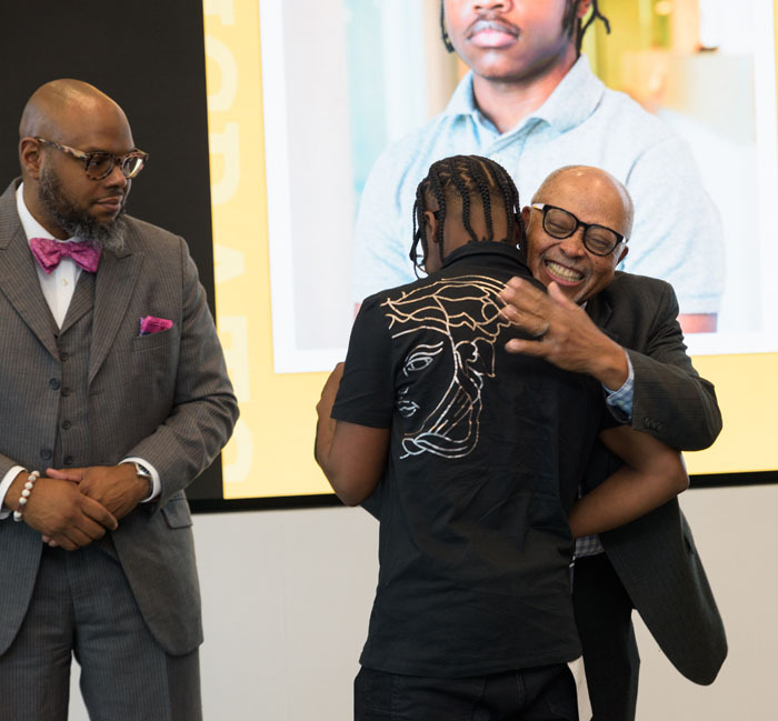 DCSEU Managing Director hugging Javar Allen-Boyd as he accepts his graduation certification for the workforce development program.