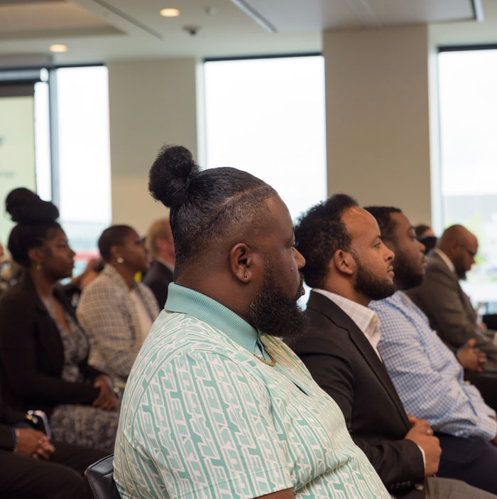 Externs sitting in the front row listening to DCSEU Managing Director, Ernest Jolly, provide opening remarks.