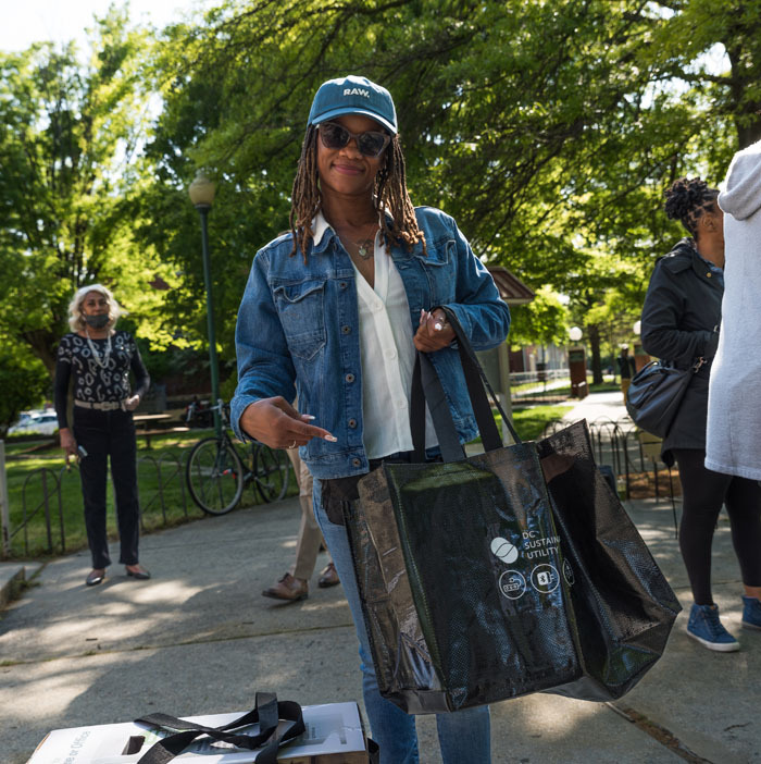 Parkside apartment complex resident holding an energy kit bag pointing to it and smiling.