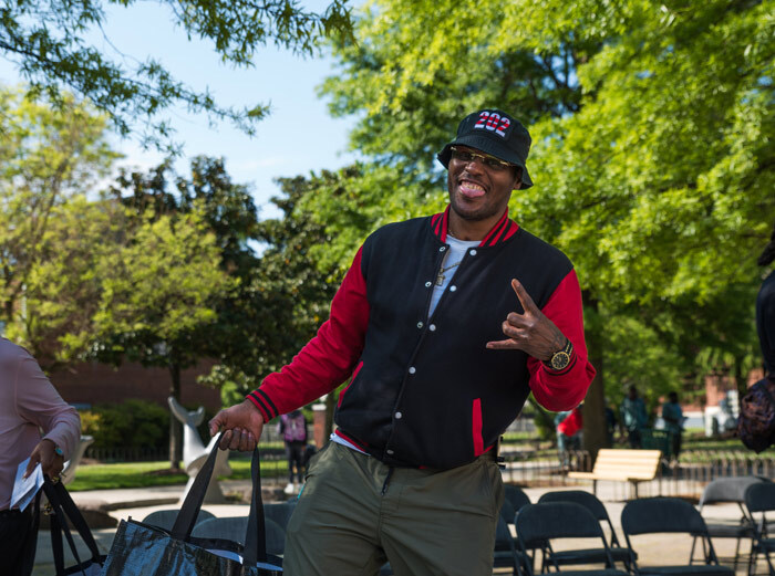 Parkside apartment complex resident in their courtyard holding an energy kit flashing the rock star hand sign and smiling.