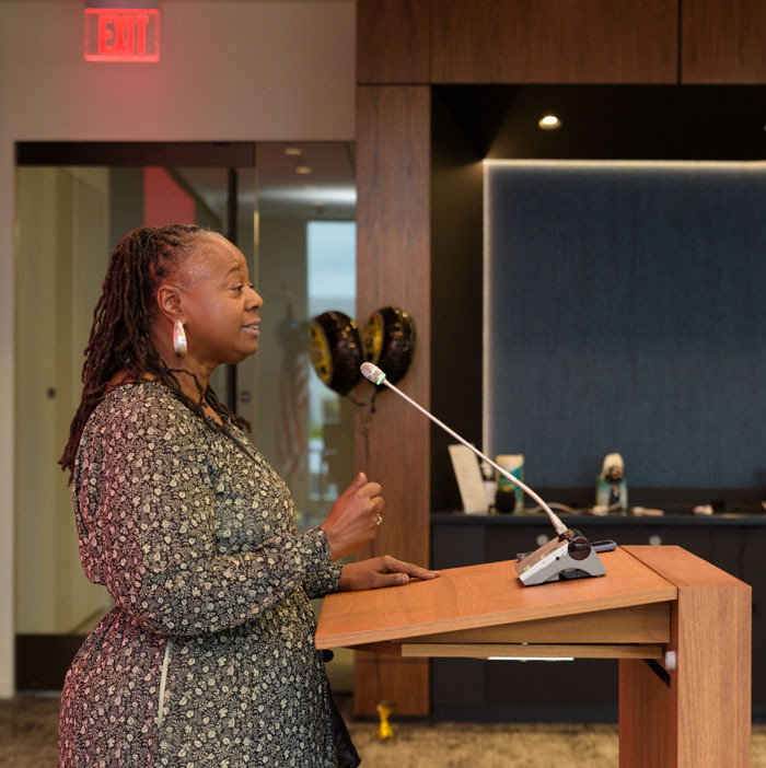 A profile of program extern, Michelle Hugee, providing the Extern’s Address to members of her cohort and graduation attendees.
