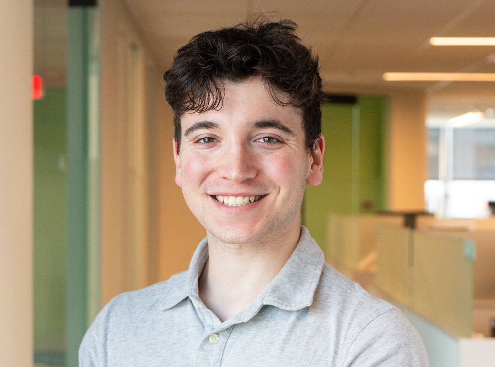 Portrait of extern, Noah Buchsbaum, in an office setting smiling.