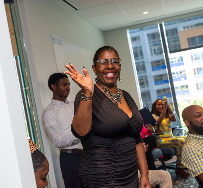 Yolanda waving to the camera while being recognized for her work with the DCSEU at the Workforce Development Program Graduation.