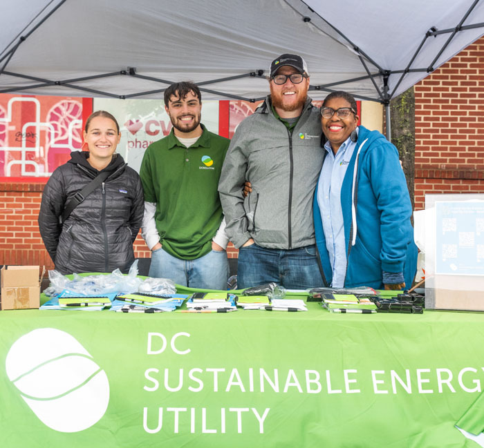 Yolanda tabling with three other DCSEU staff members in the rain at Georgia Ave Open Streets.
