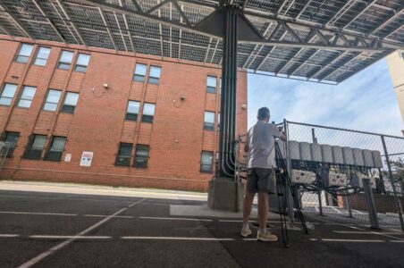 Camera man recording footage of the inverters at the Sargent Memorial Parking Lot Solar Canopy.