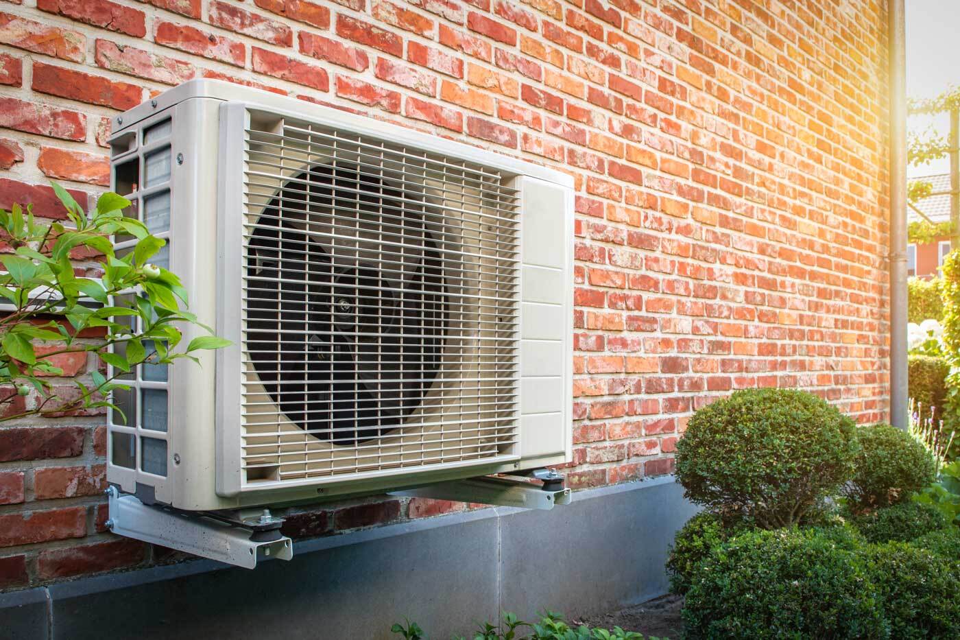 Elevated heat pump compressor outside of a building.