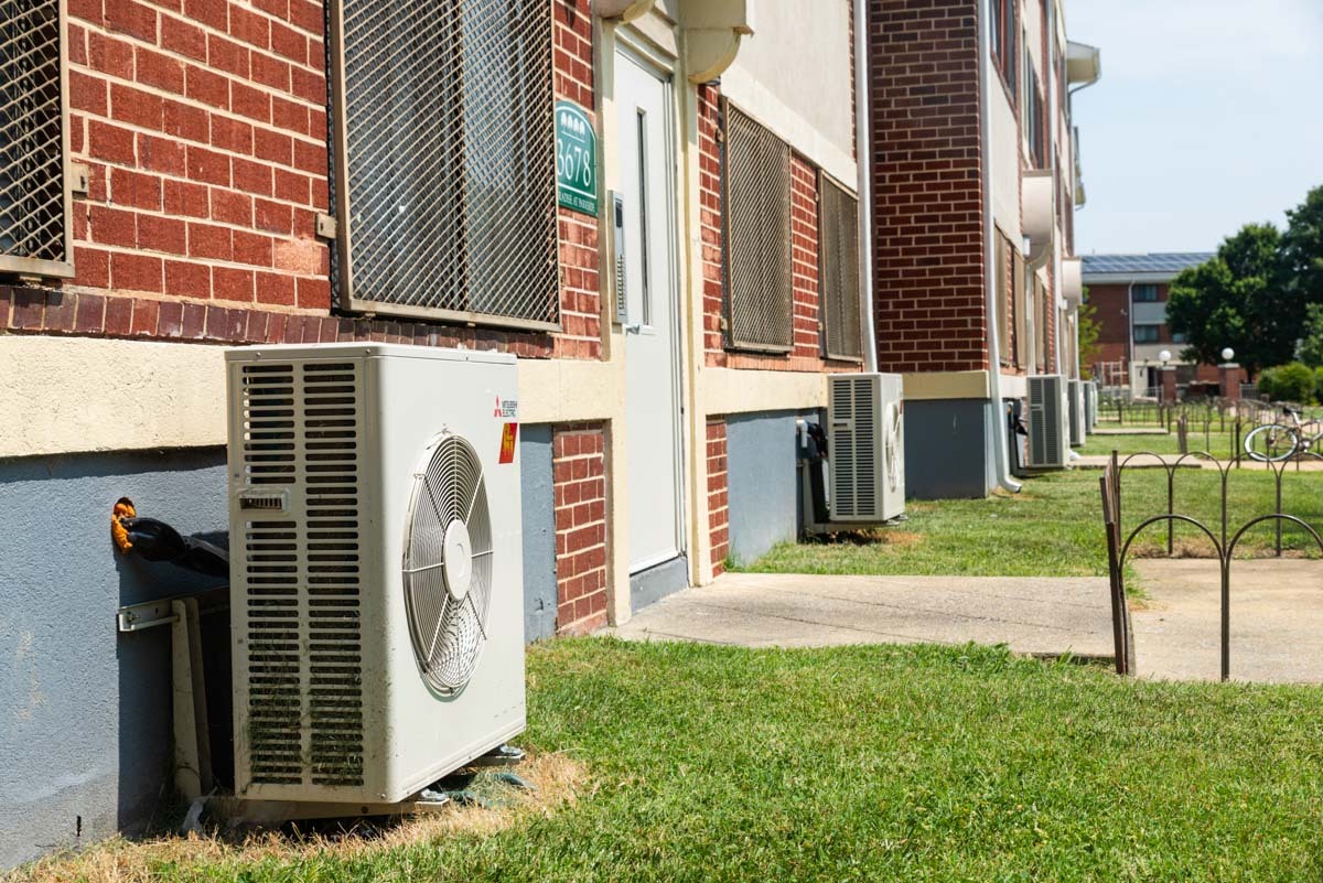 Multiple heat pump compressors outside of Parkside Apartment Complex.