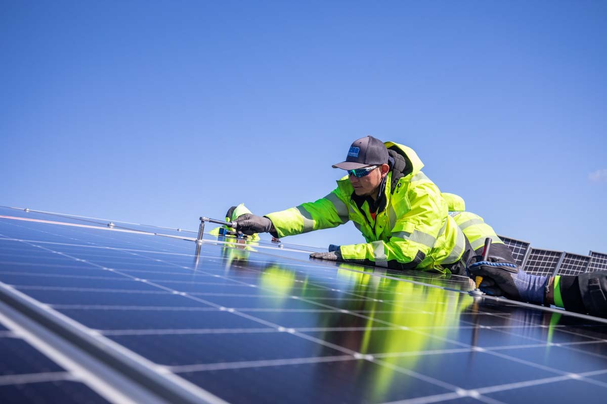 Solar installer tightening a bolt on a ground mounted array.