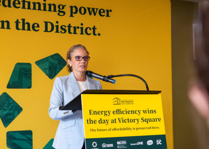 Leila A. Finucane, J.D., M.U.P., President and CEO of Victory Housing, providing remarks from the podium.