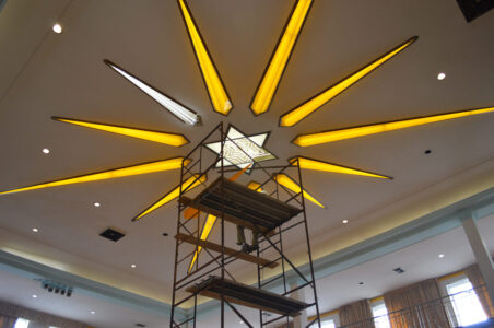 Scaffolding going up towards a LED Star of David on the ceiling of a house of worship.