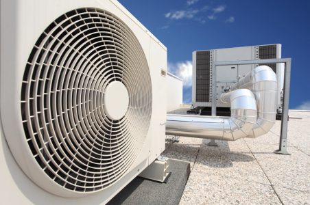 Commercial building rooftop ventilation and pipes for heating and cooling.