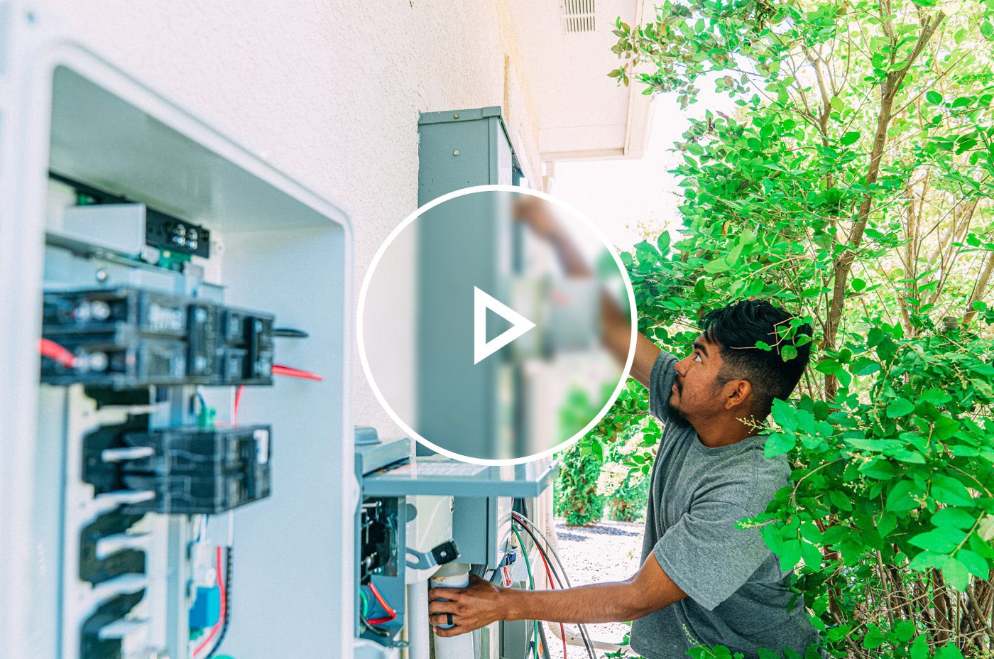 An electrician outside of a home upgrading the electric service panel to 200 amps, also known as a heavy-up.