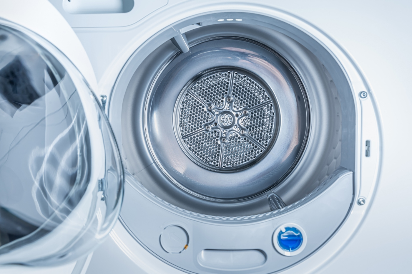 A view inside the metallic drum of a front-loading heat pump clothes dryer.