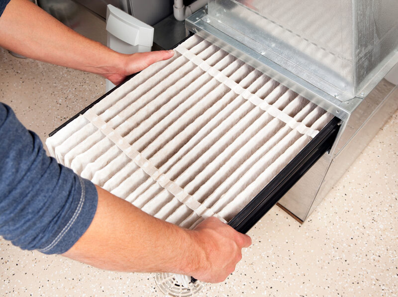 Closeup of an HVAC tech replace and air filter from an air handler.