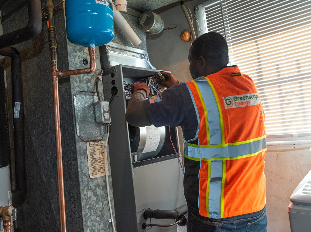 HVAC tech working on the wiring of a ducted heat pump air handler.