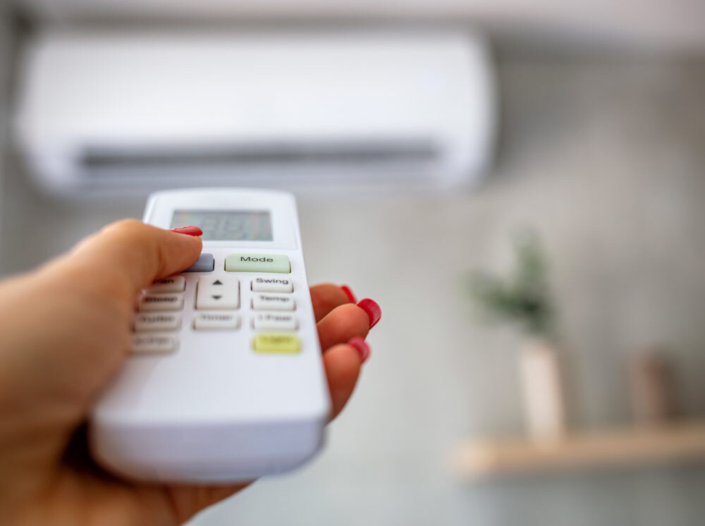 Close up of a remote pointed toward a mini split heat pump air handler.