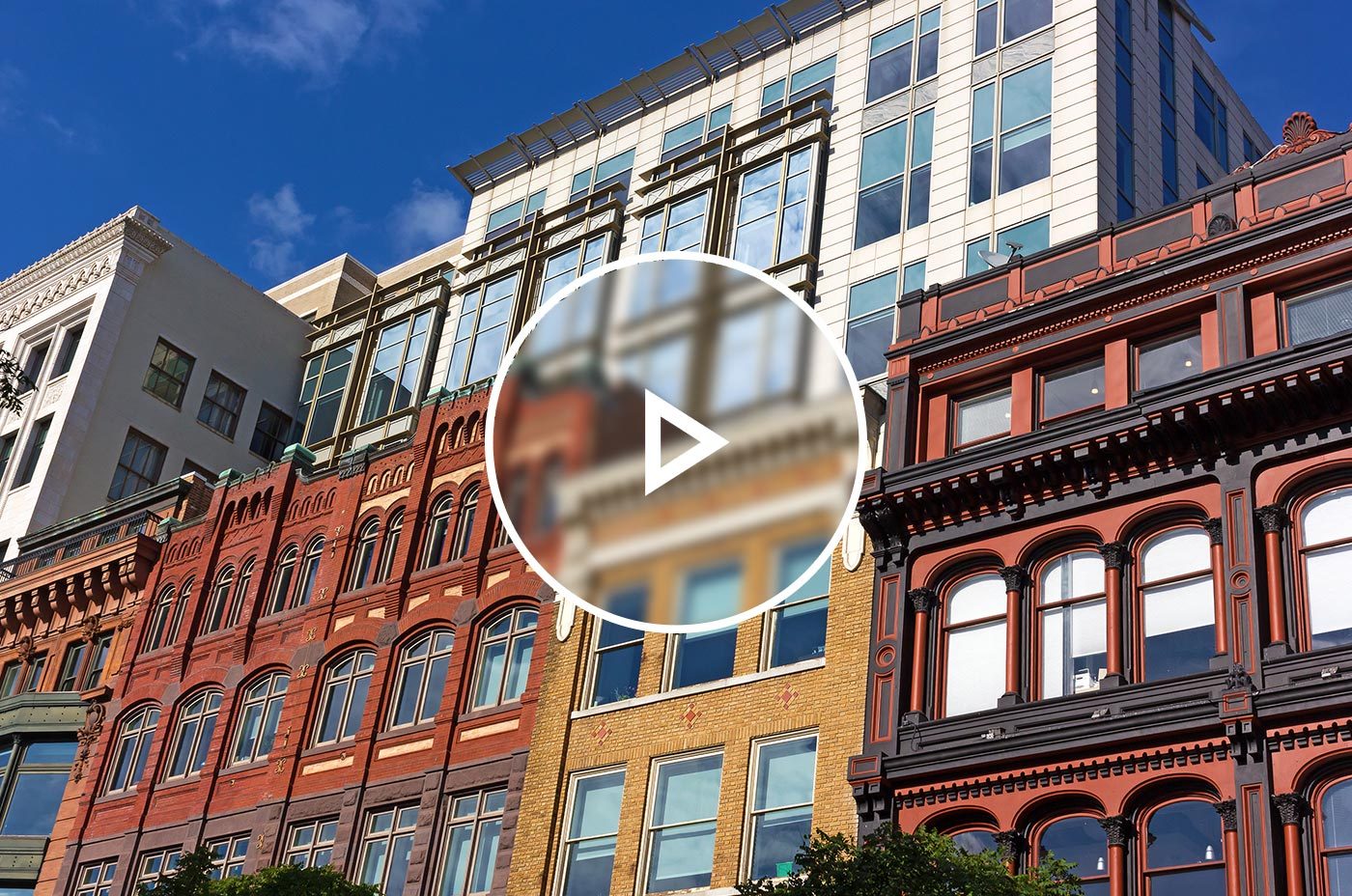 Colorful and multiple facades of commercial and multifamily buildings in downtown DC stacked on top of on another during a sunny day.